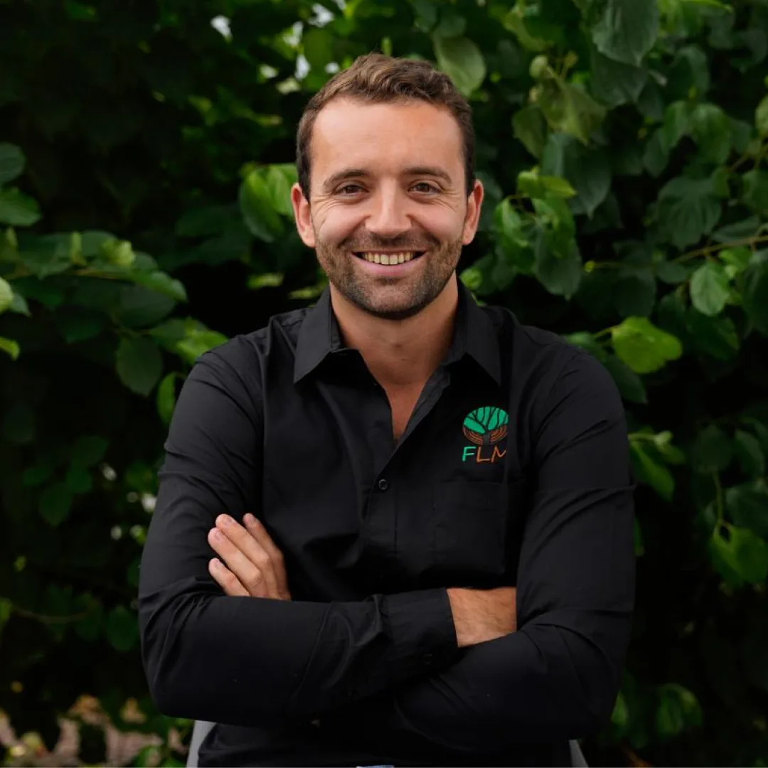 Portrait de Guillaume Fresneau, responsable de secteur, devant un feuillage